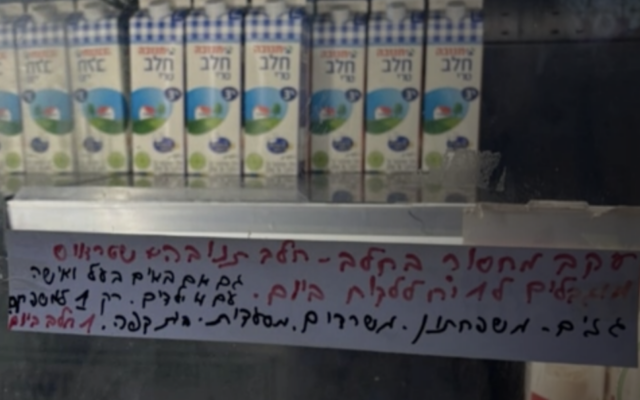 Une affichette limitant les clients à une seule brique de lait dans un supermarché non nommé, diffusée sur la chaîne N12 le 26 août 2025. (Crédit : Capture d'écran/N12)